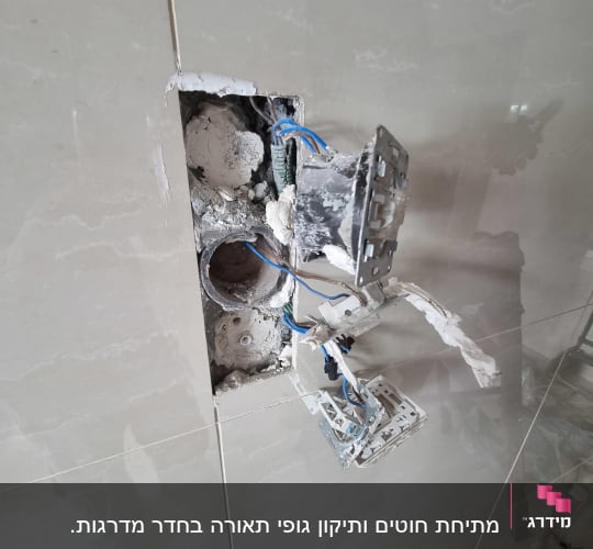 שקע חשמלי פתוח עם חוטים חשופים בקיר